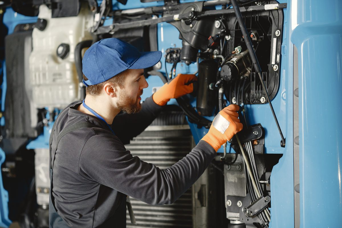 Mecânico fazendo manutenção no motor de um veículo pesado